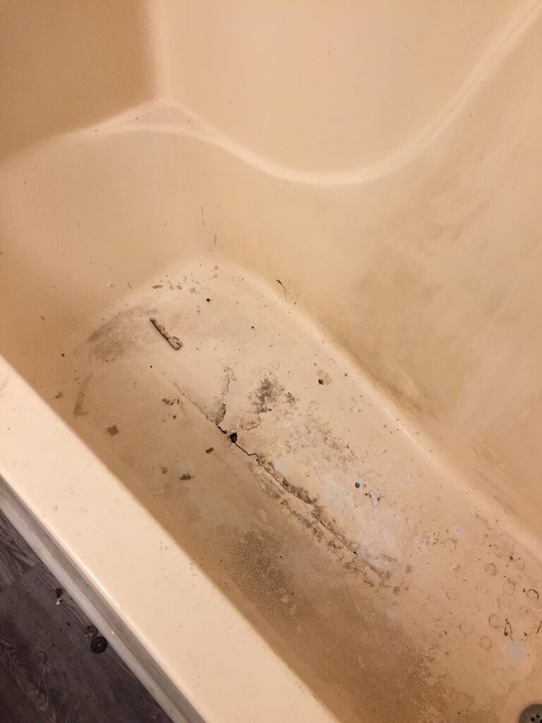 Tub with large crack at bottom, in need of repair before can be used