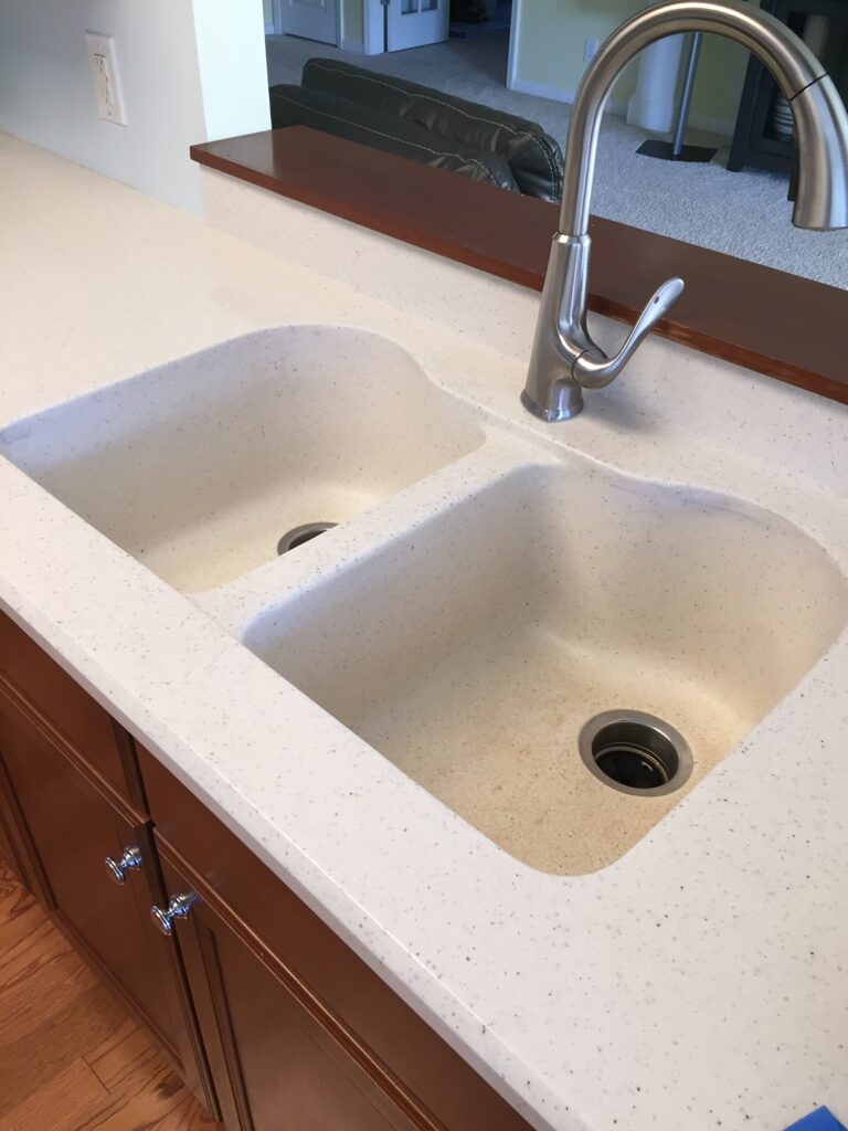 Corian countertop with light-colored built-in sink that was stained, and looking unsanitary (BEFORE)
