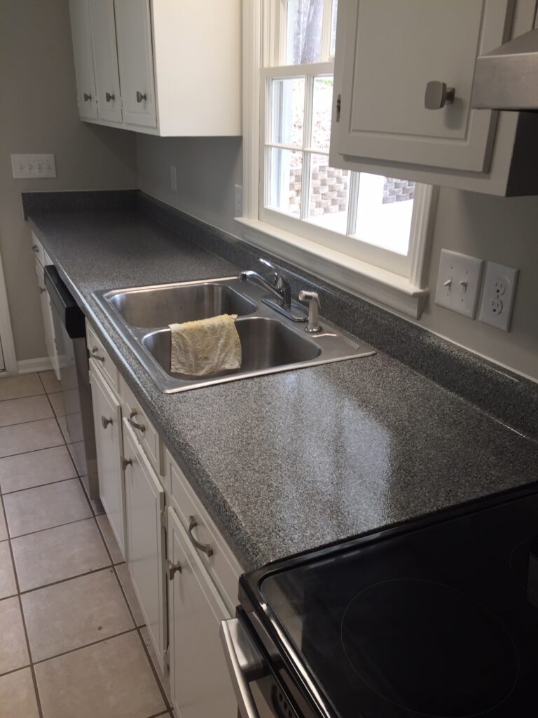 Countertop repaired, then resurfaced with a multifleck "Galena Gray", followed with a clear semi-gloss epoxy topcoat (AFTER)