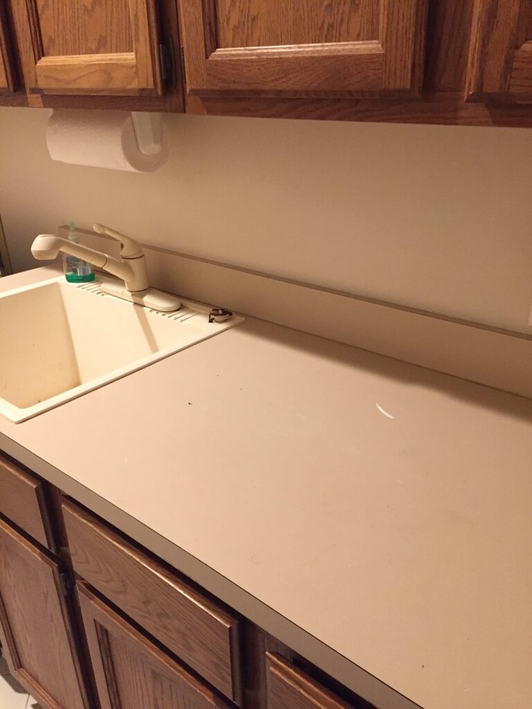 Laundry room - old Laminate countertop, dated and unsightly with square edging, sink was also stained and in need of a fresh touch (BEFORE) 